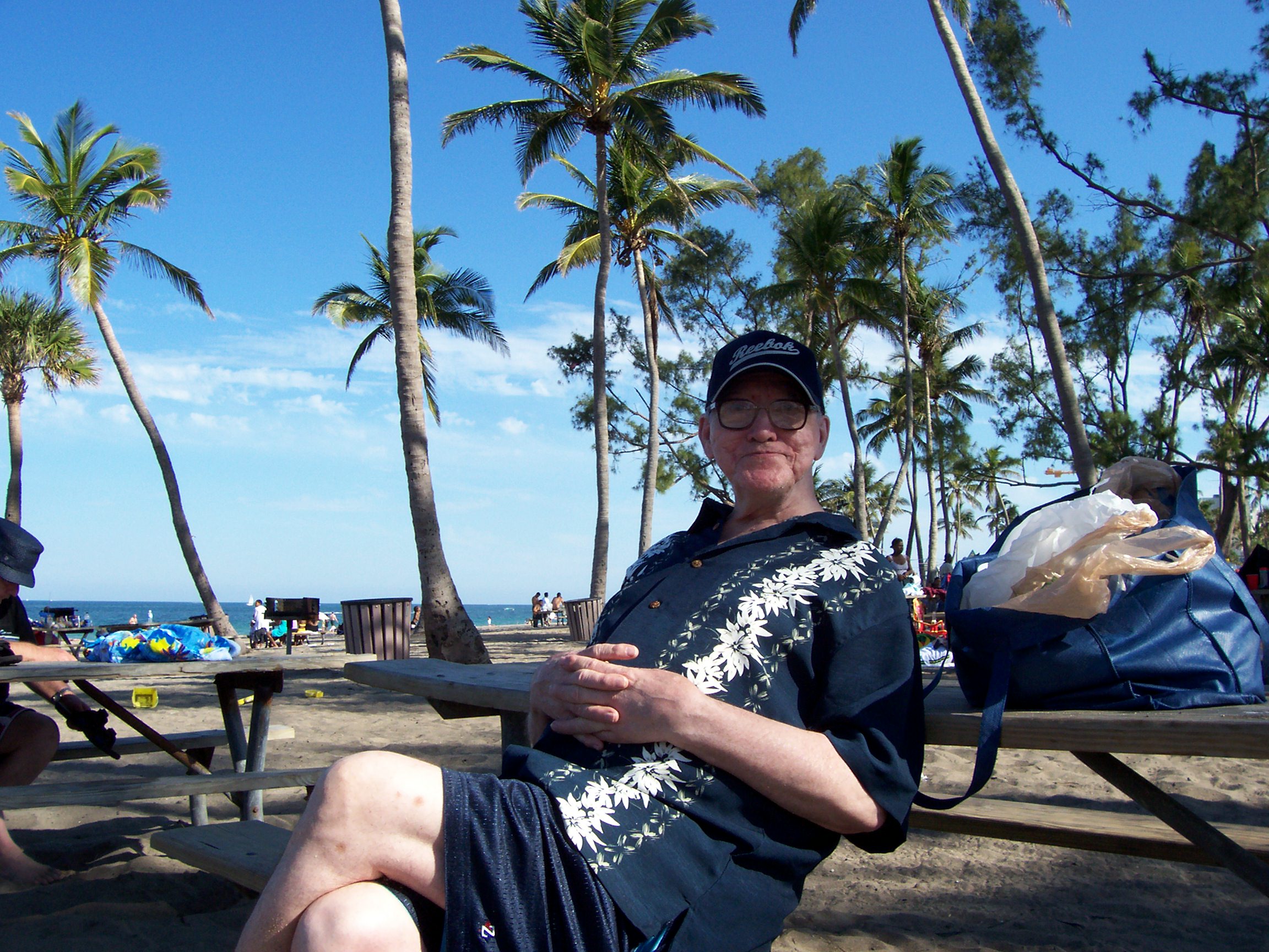 A Newbridge resident relaxes at a picnic table beneath palm trees on a Florida beach during the annual resident vacation